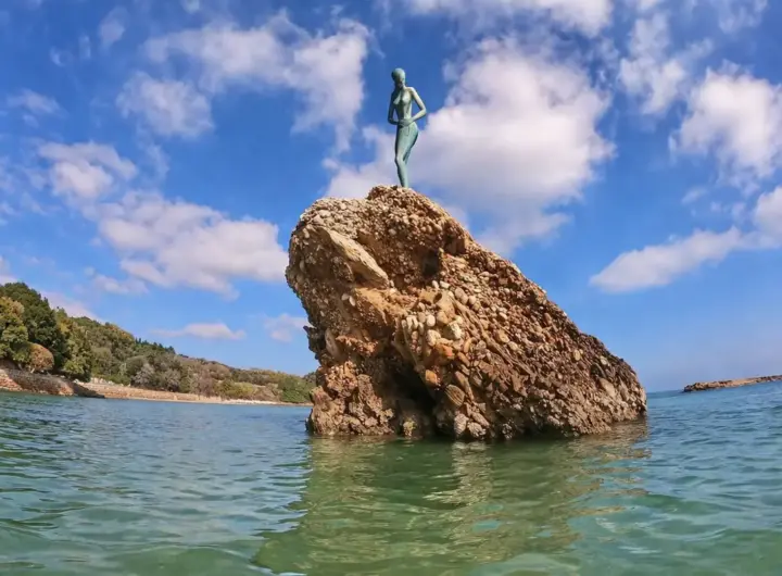 Statua sopra roccia sul mare