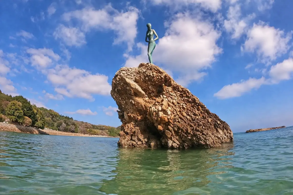 Statua sopra roccia sul mare